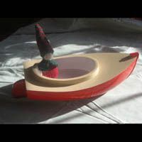 a red and white boat with a gnome on top of it is sitting on a table .