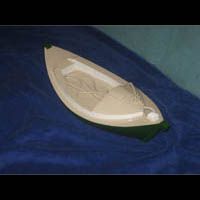 a small boat is floating on top of a blue surface .