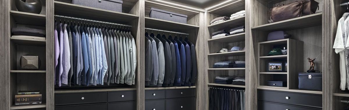  Drift raven finish closets filled with a variety of clothes in a walk-in closet.