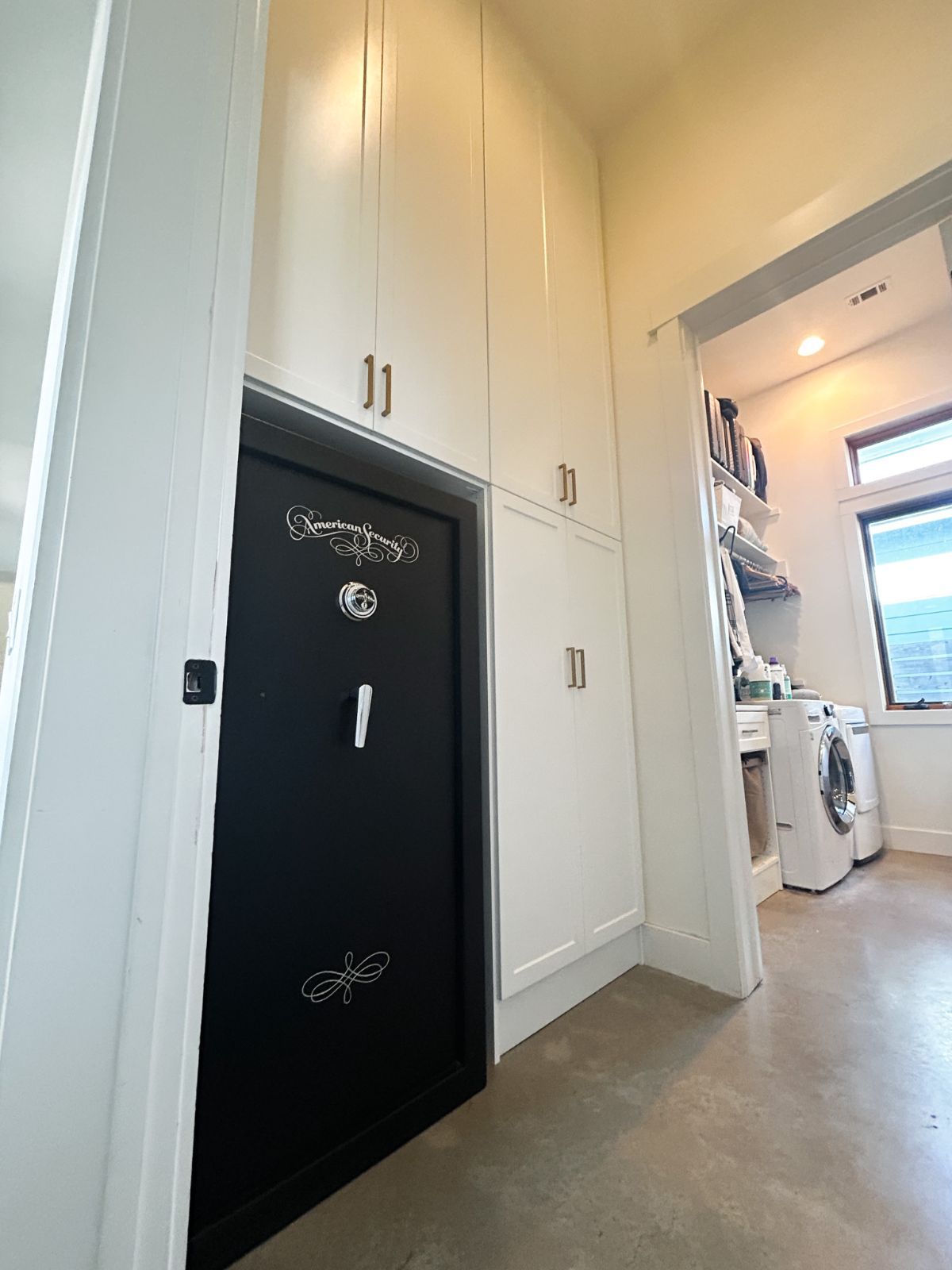 A laundry room with a safe and a washer and dryer
