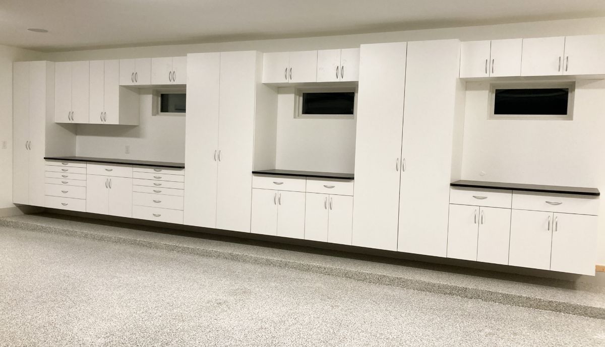 A kitchen with white cabinets and a gray floor
