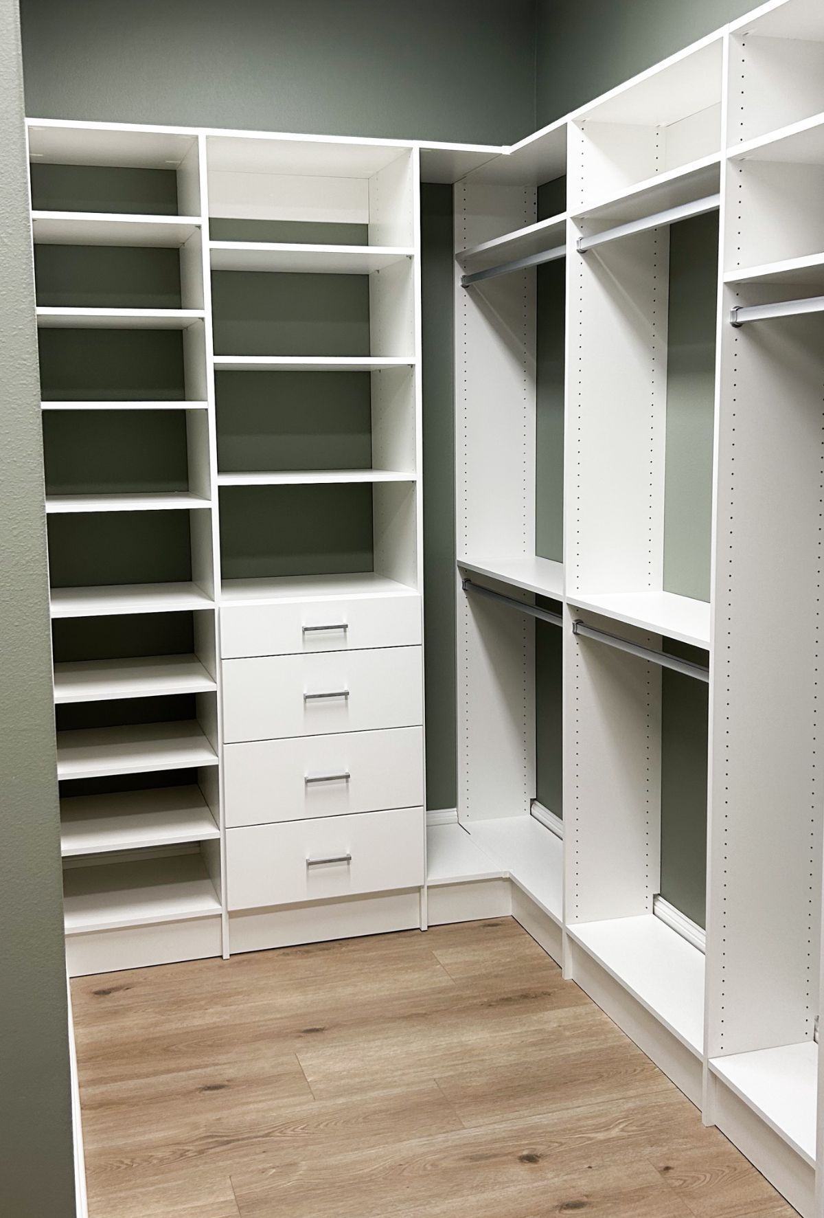 A walk in closet with lots of shelves and drawers.