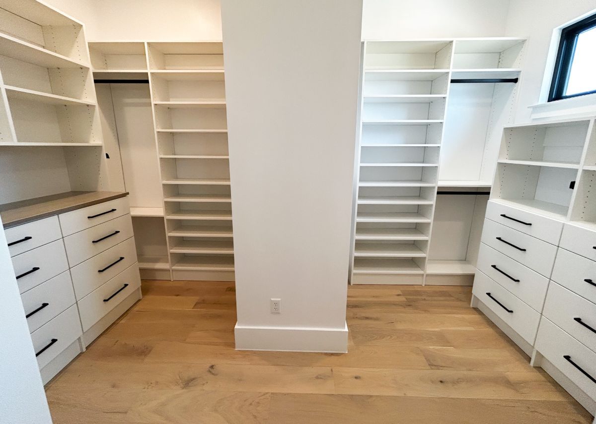 A walk in closet with lots of shelves and drawers.
