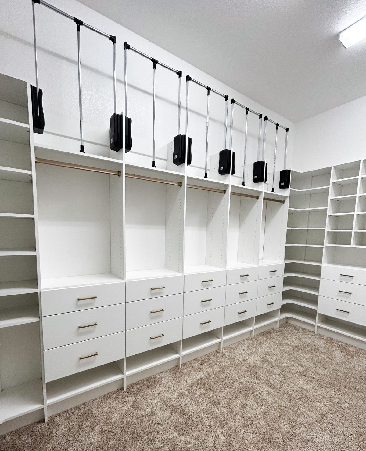 A walk in closet with lots of shelves and drawers