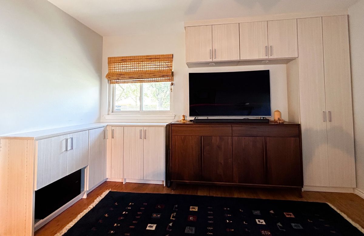 A living room with a flat screen tv and a rug