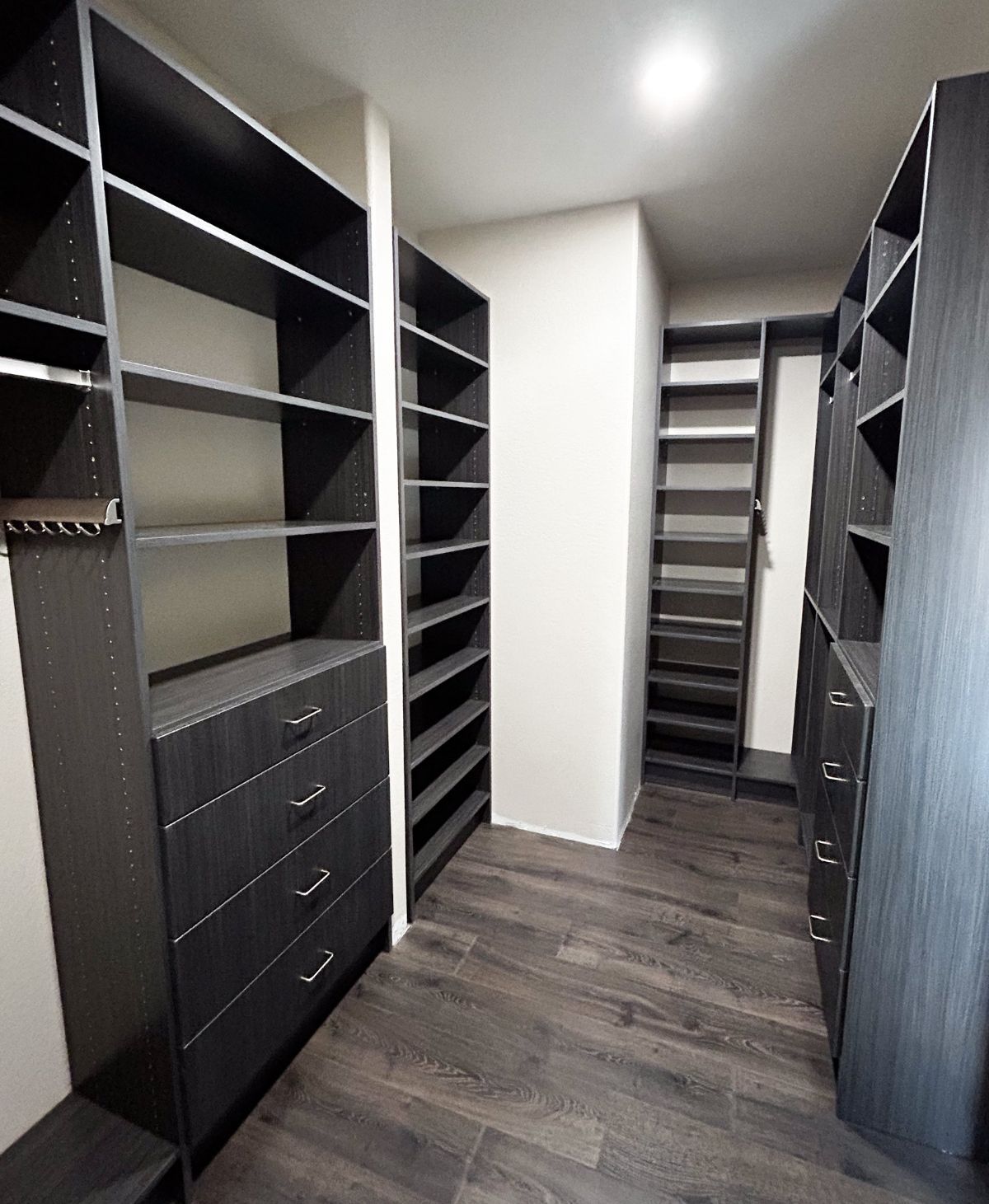 A walk in closet with lots of shelves and drawers