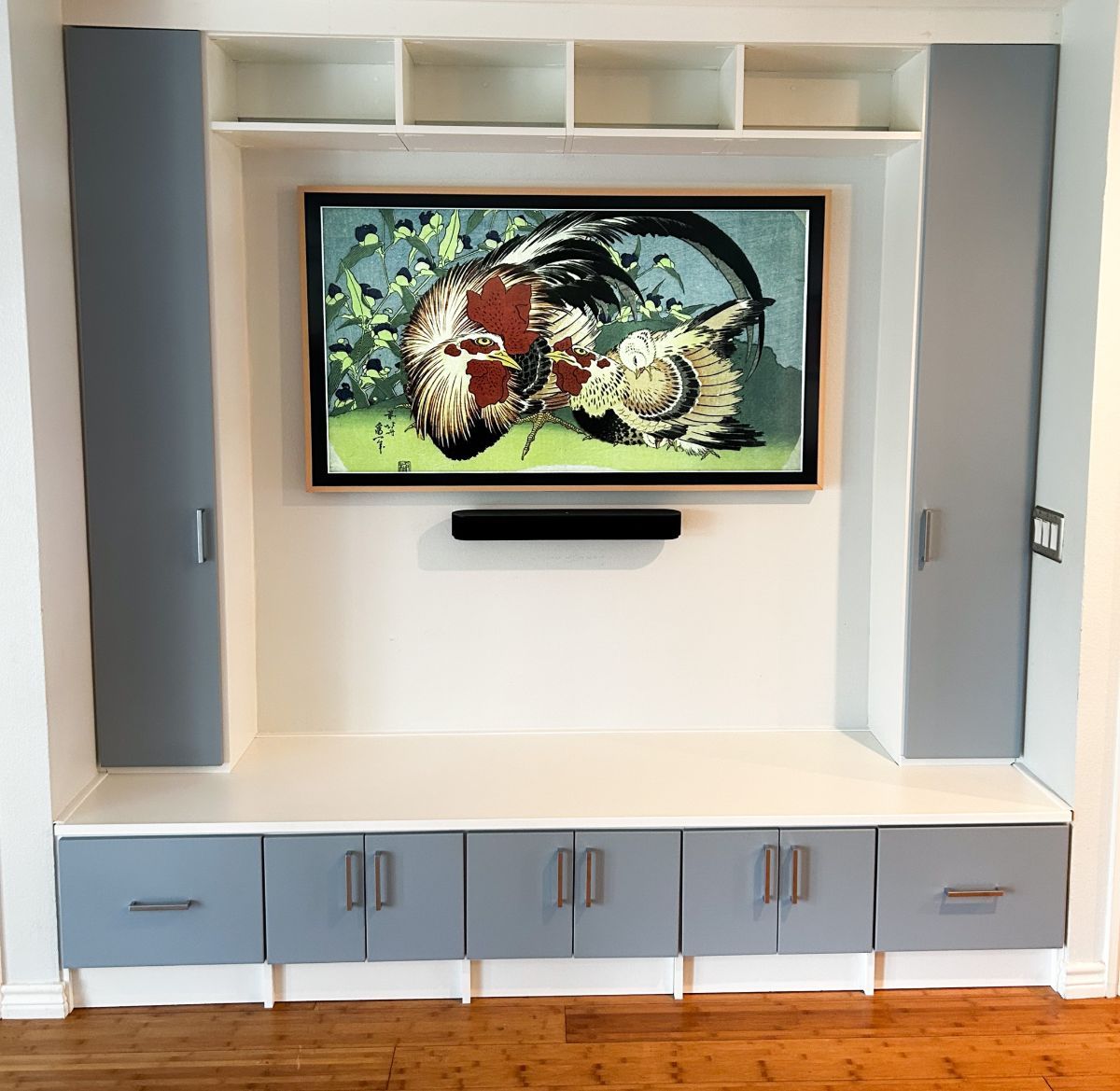 A picture of a rooster on a wall above a tv