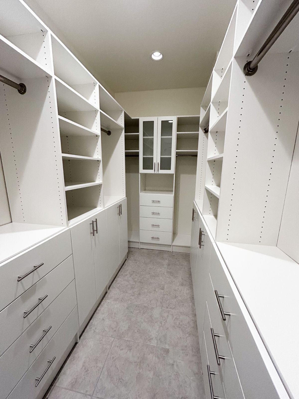 A walk in closet with lots of shelves and drawers