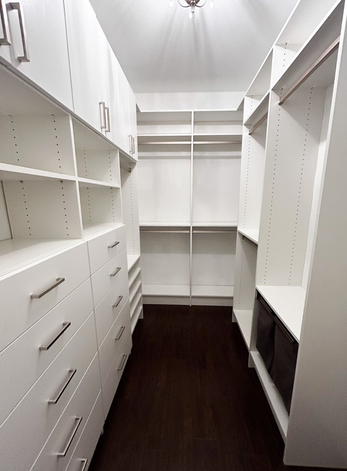 A walk in closet with lots of shelves and drawers