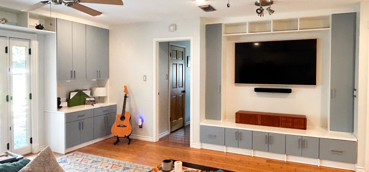 A living room with a flat screen tv and a guitar.