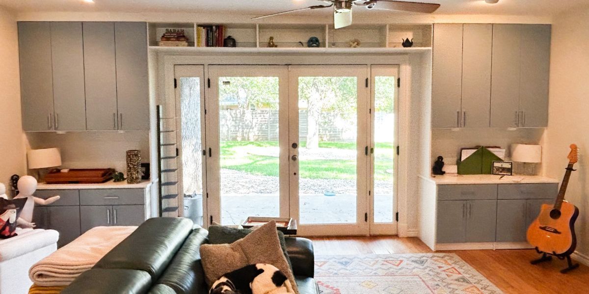 A living room with a couch , guitar , and sliding glass doors.