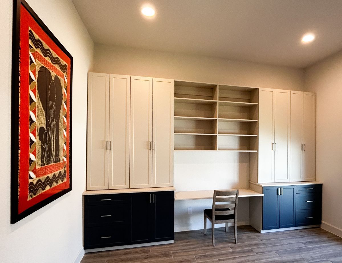 a home office room with custom cabinets and drawers