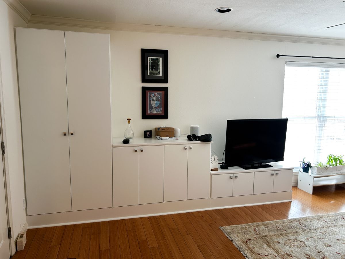 A living room with white cabinets and a flat screen tv