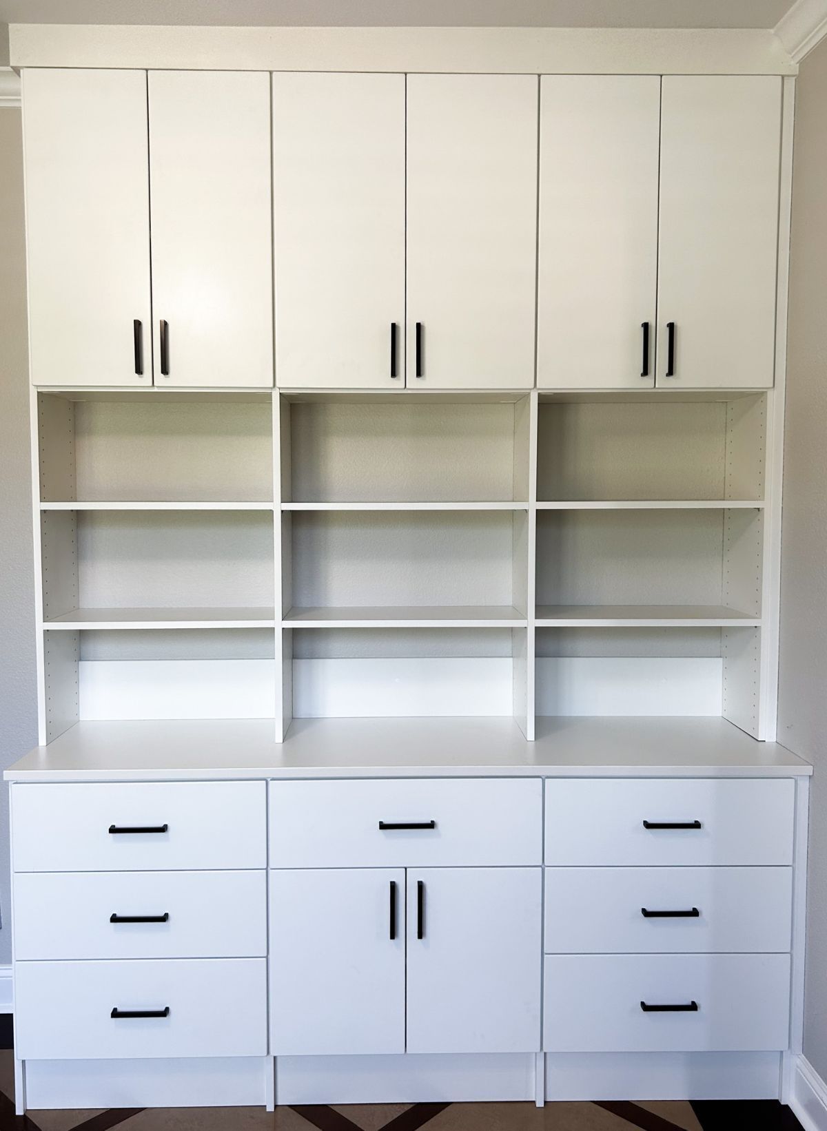 White cabinets with black handles and drawers in a room