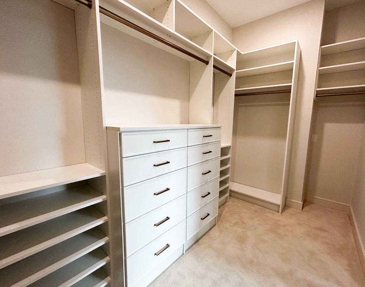 A walk in closet with lots of drawers and shelves