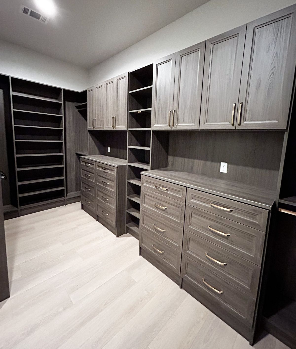 A walk in closet with lots of drawers and shelves