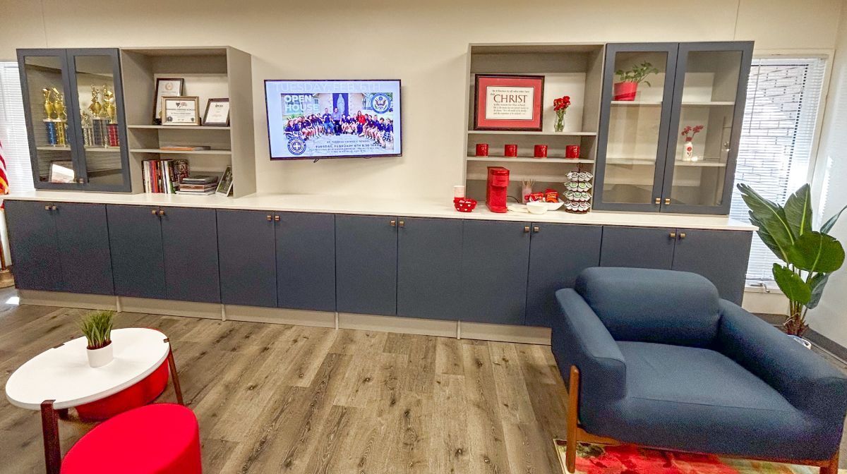 A living room with a chair , table , and television on the wall.