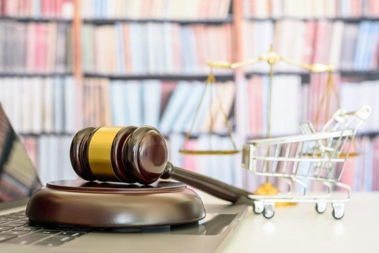 A judge 's gavel is sitting on top of a laptop computer.