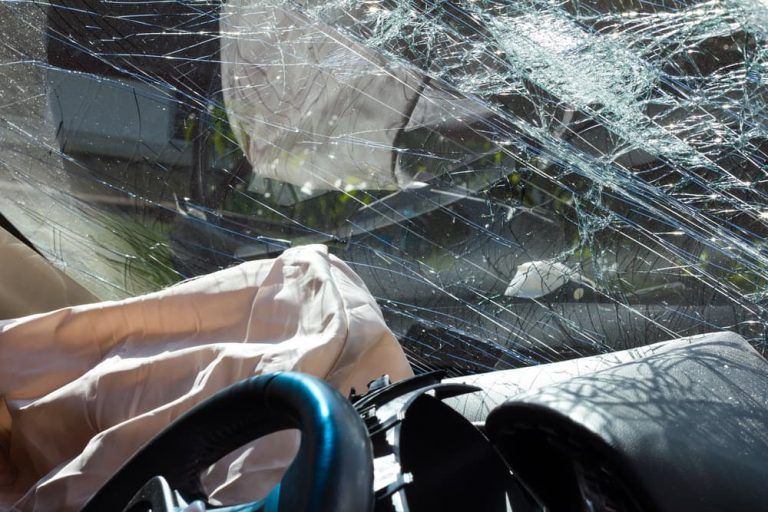 A car with a broken windshield and steering wheel