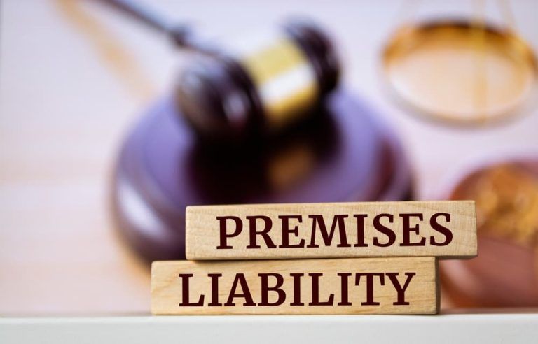 The words premises liability are written on wooden blocks in front of a judge 's gavel.