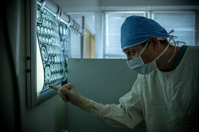 A surgeon is looking at an x-ray in a hospital.