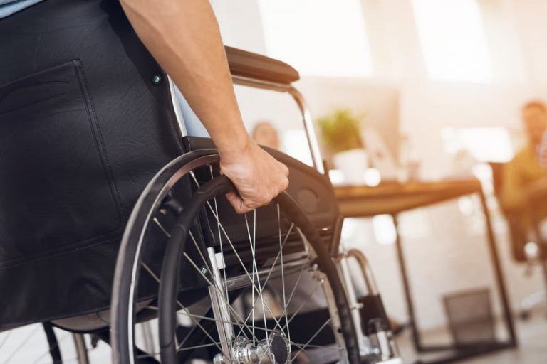 A man in a wheelchair is holding the wheel.