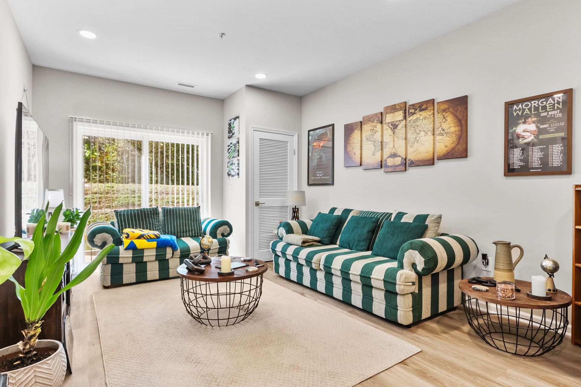 Living room with striped sofas, coffee tables, and wall art. Sliding door to a deck.