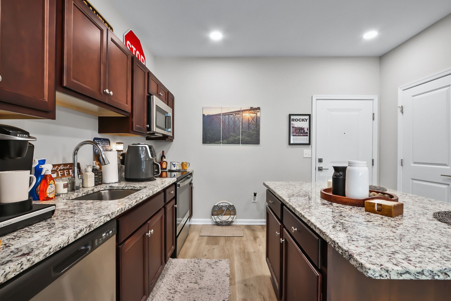 Kitchen with dark brown cabinets, granite countertops, and stainless steel appliances.