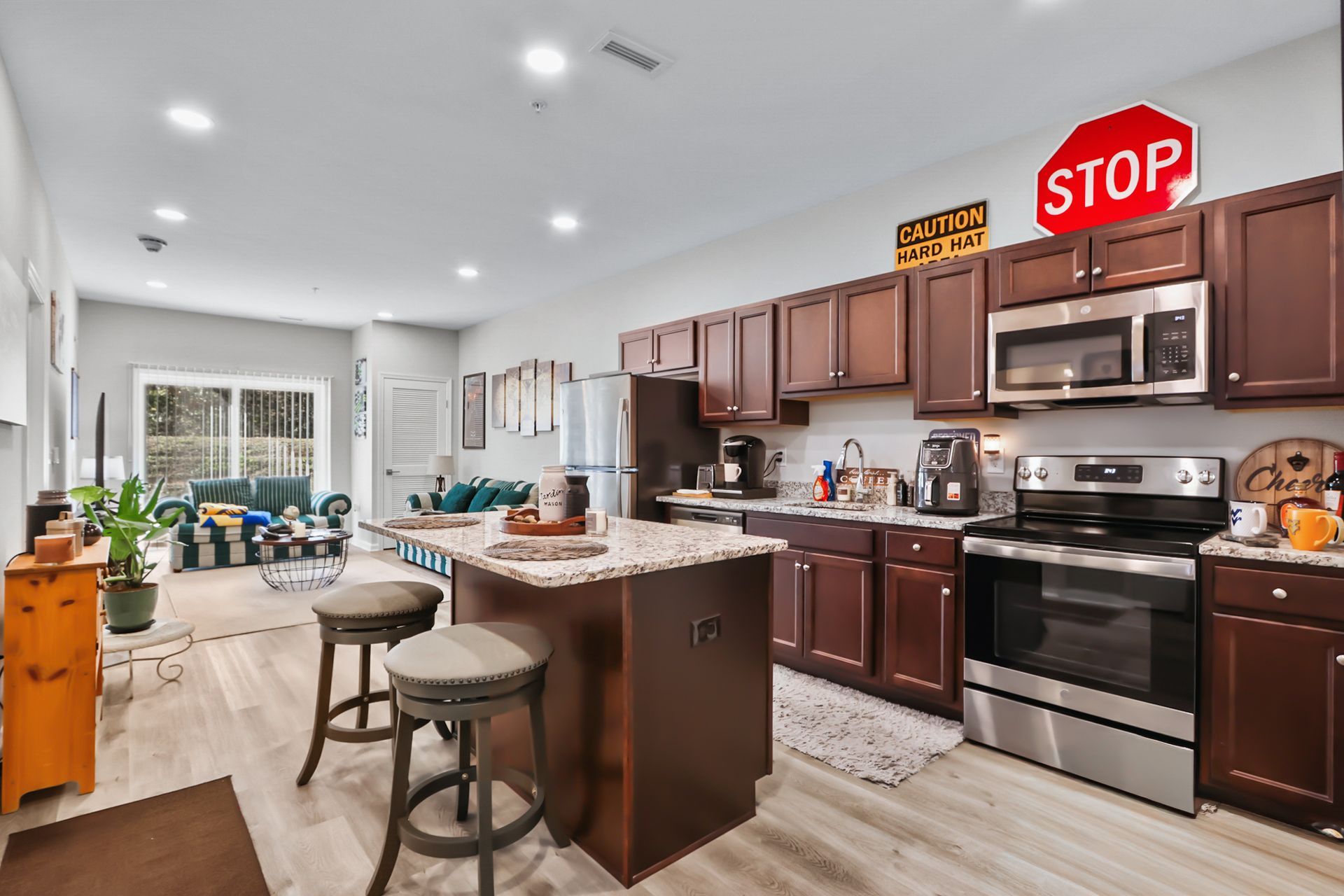 Kitchen with dark cabinets, stainless steel appliances, and a stop sign.