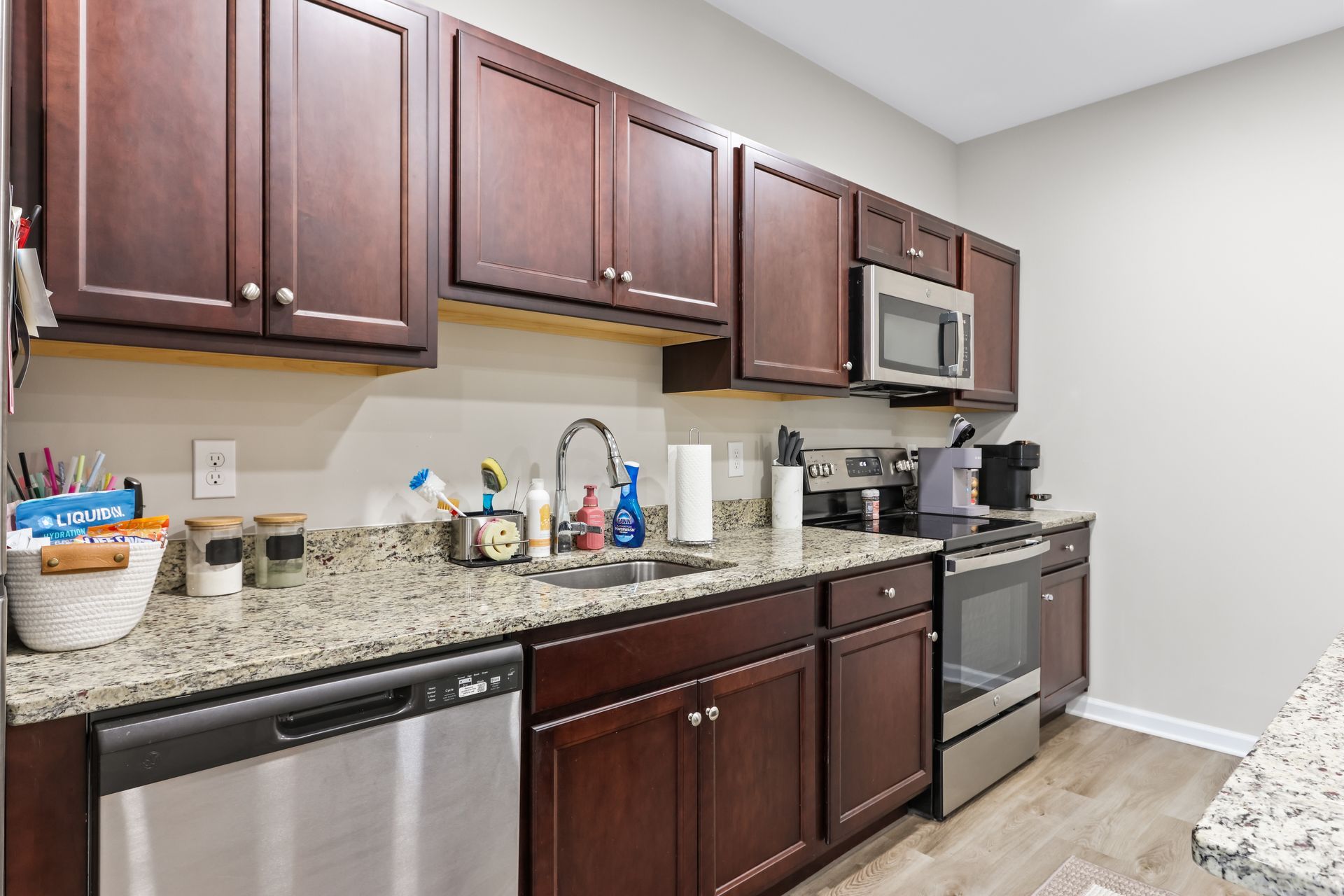 Kitchen with dark cabinets, stainless steel appliances, and granite countertops.