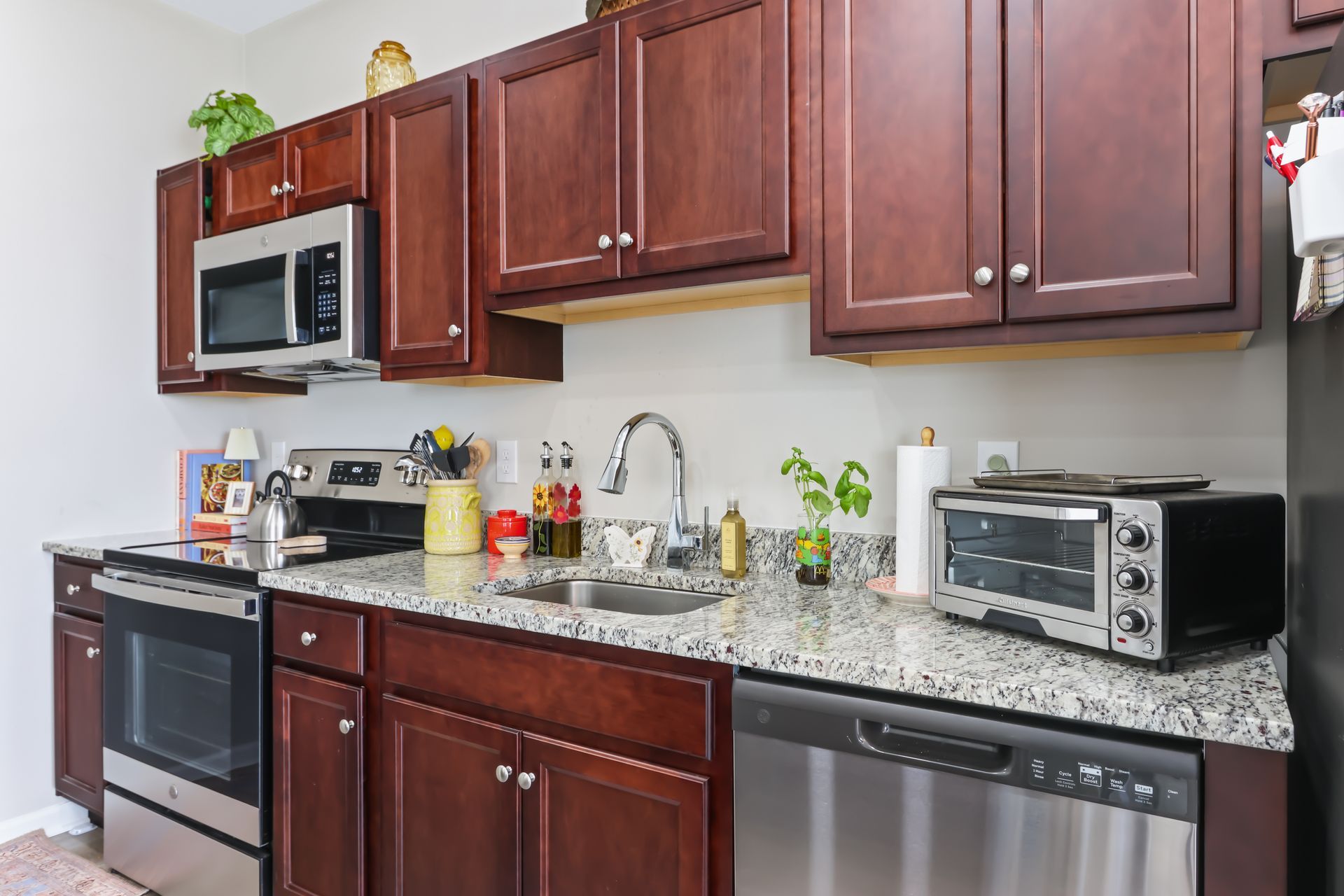 Kitchen with dark cabinets, stainless steel appliances, and granite countertops.