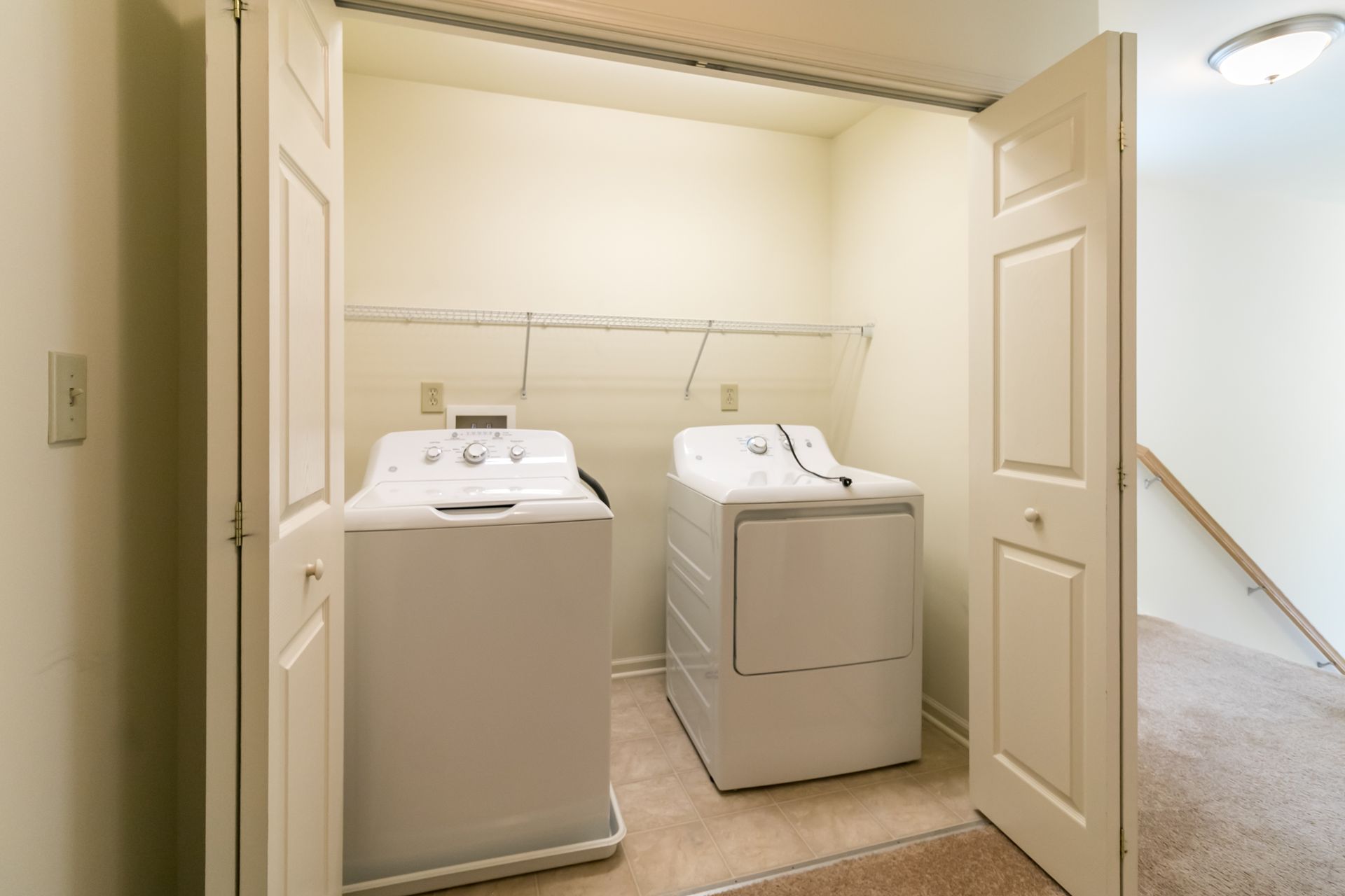Laundry appliances, washer and dryer, in a closet with open doors.
