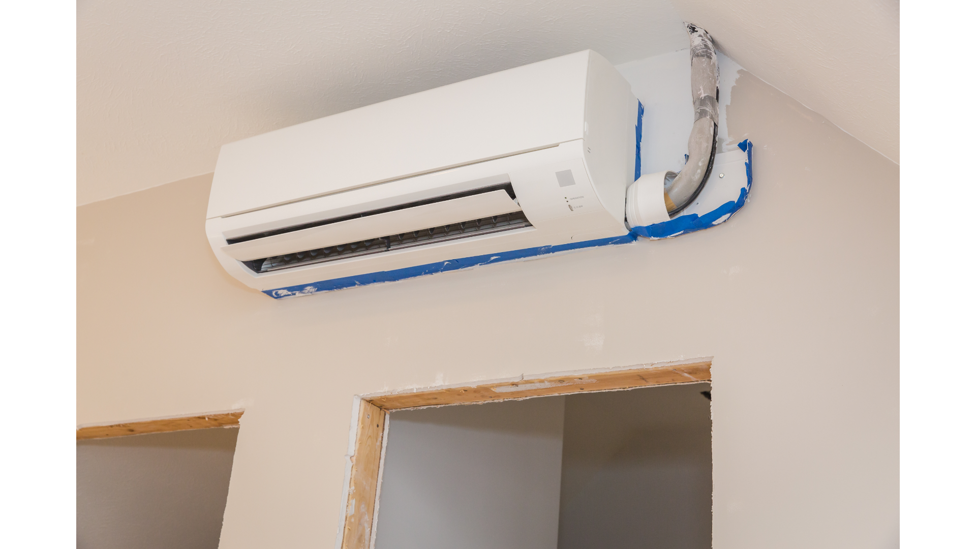A wall mounted air conditioner is being installed in a room.