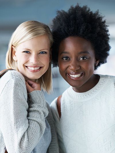 Two people with smiling expressions standing side-by-side