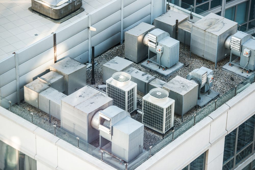 An aerial view of a building with a lot of air conditioning equipment on the roof.