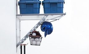 a shelf with a helmet , glove , and ball storage basket on it .