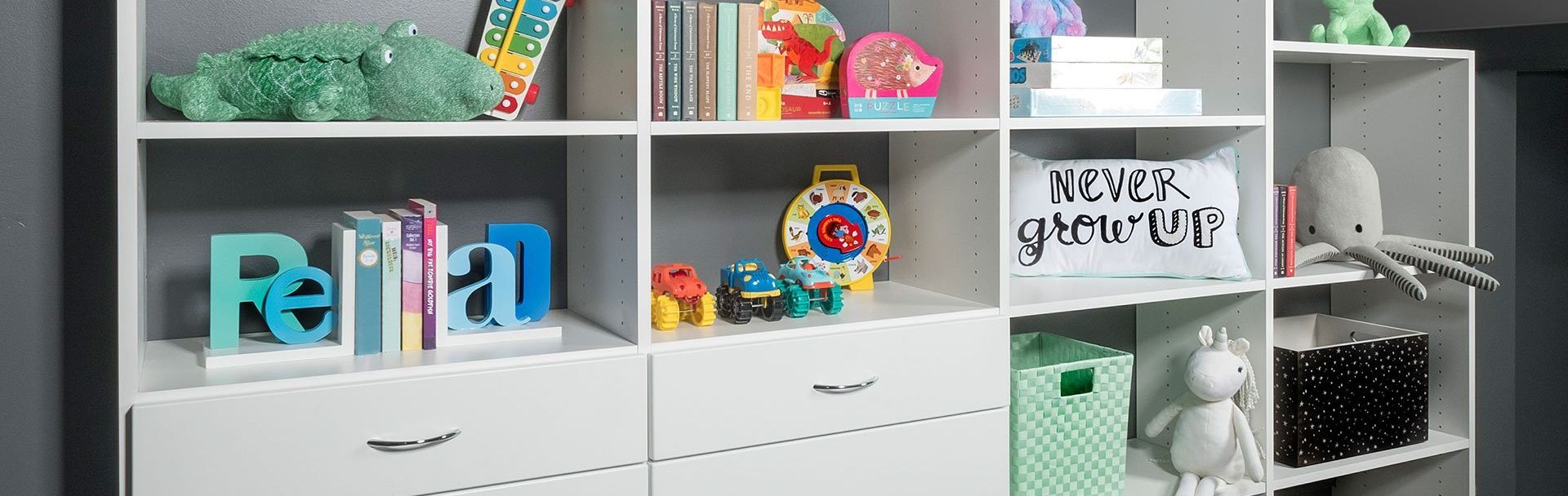 A kids room with lots of shelves and drawers filled with toys and books.