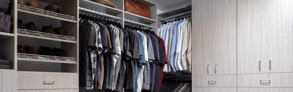 a closet system cabinet filled with hanging shirts and organized shoe fences 