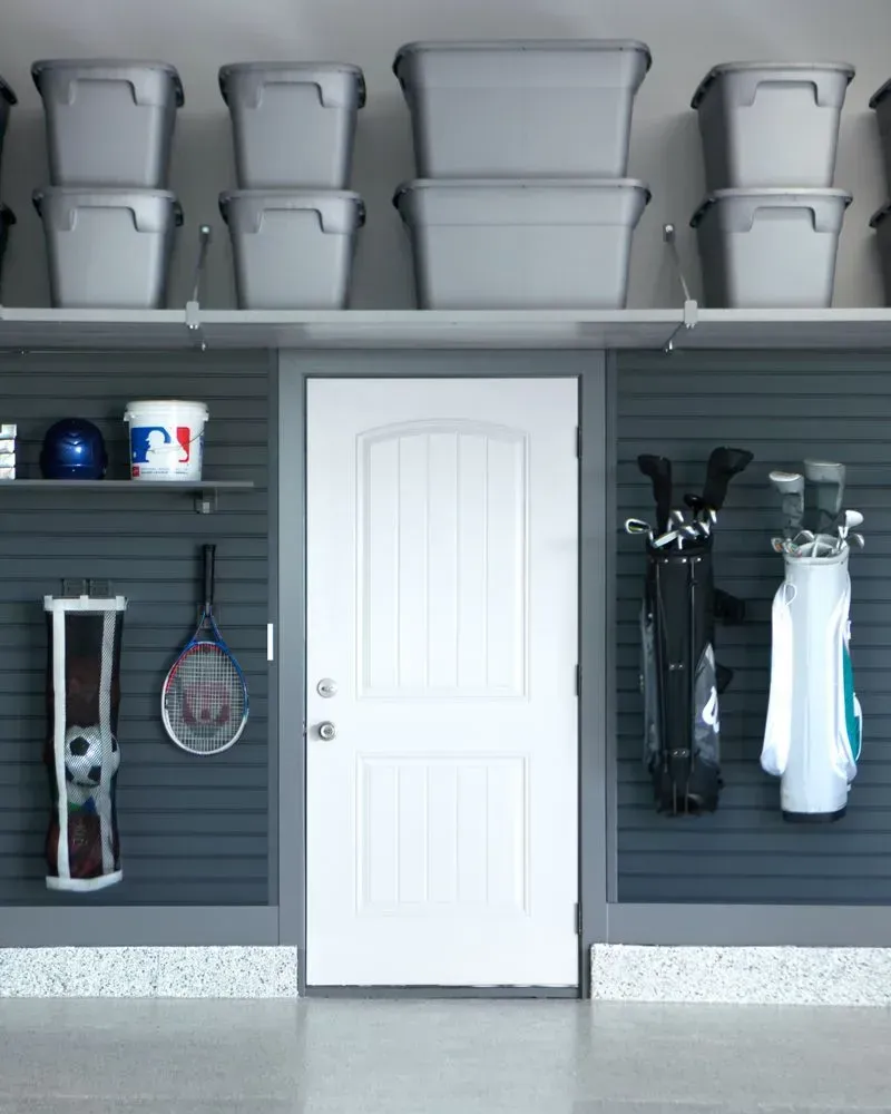 a white door in a garage surrounded by shelves and boxes