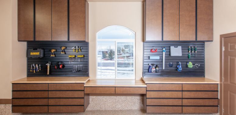 a garage with lots of cabinets and drawers and a workbench .