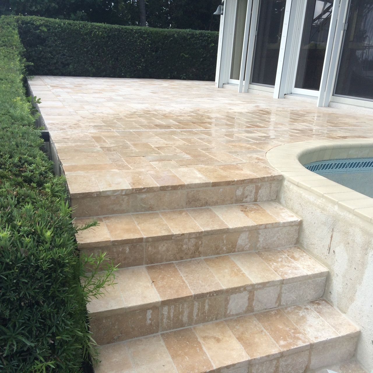 A set of stairs leading up to a patio next to a pool.