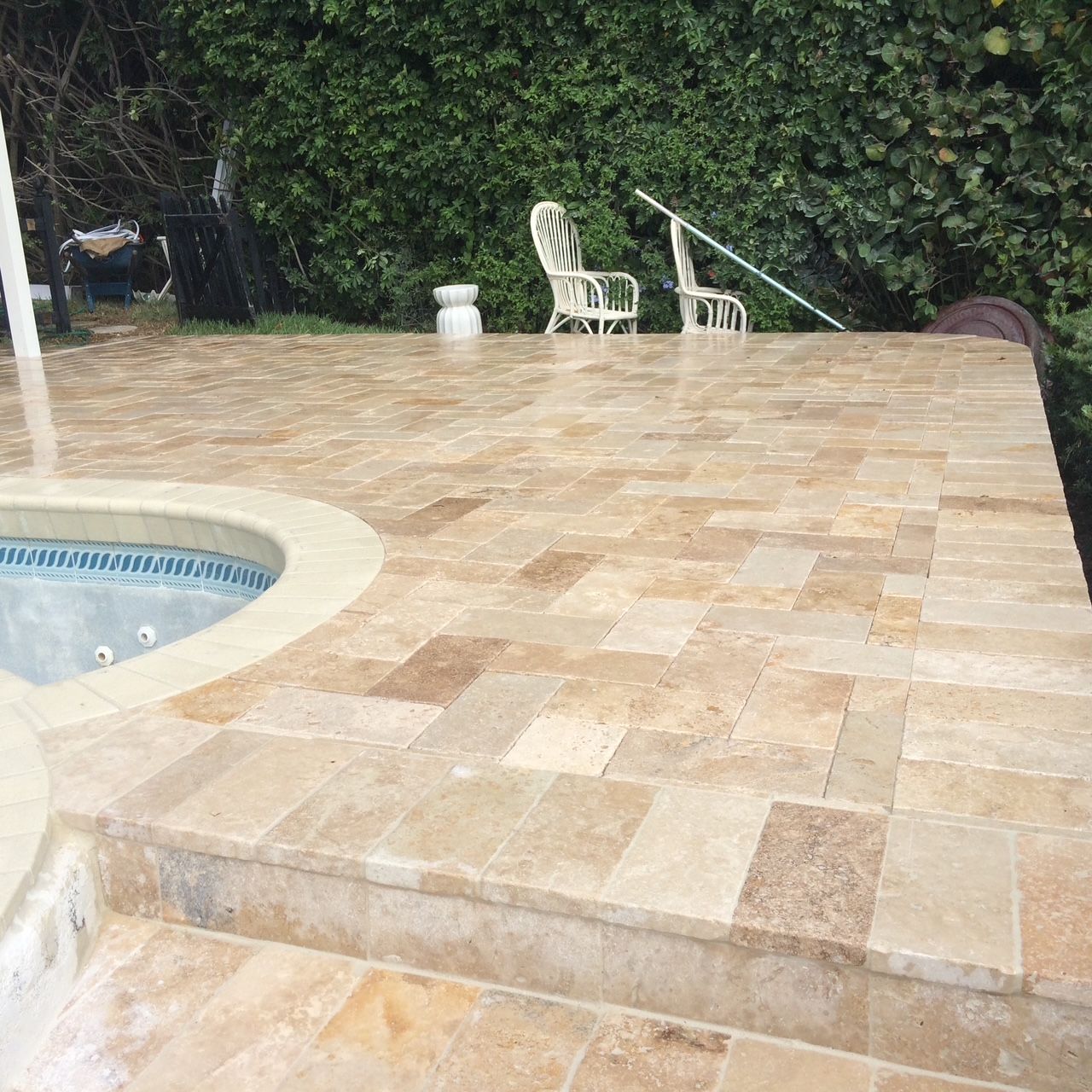 A patio with a swimming pool in the background