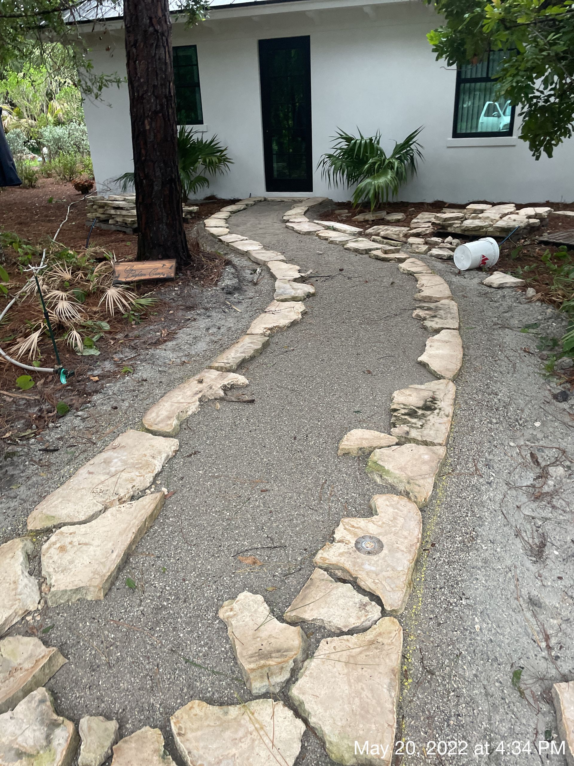 A stone walkway leading to a white house.