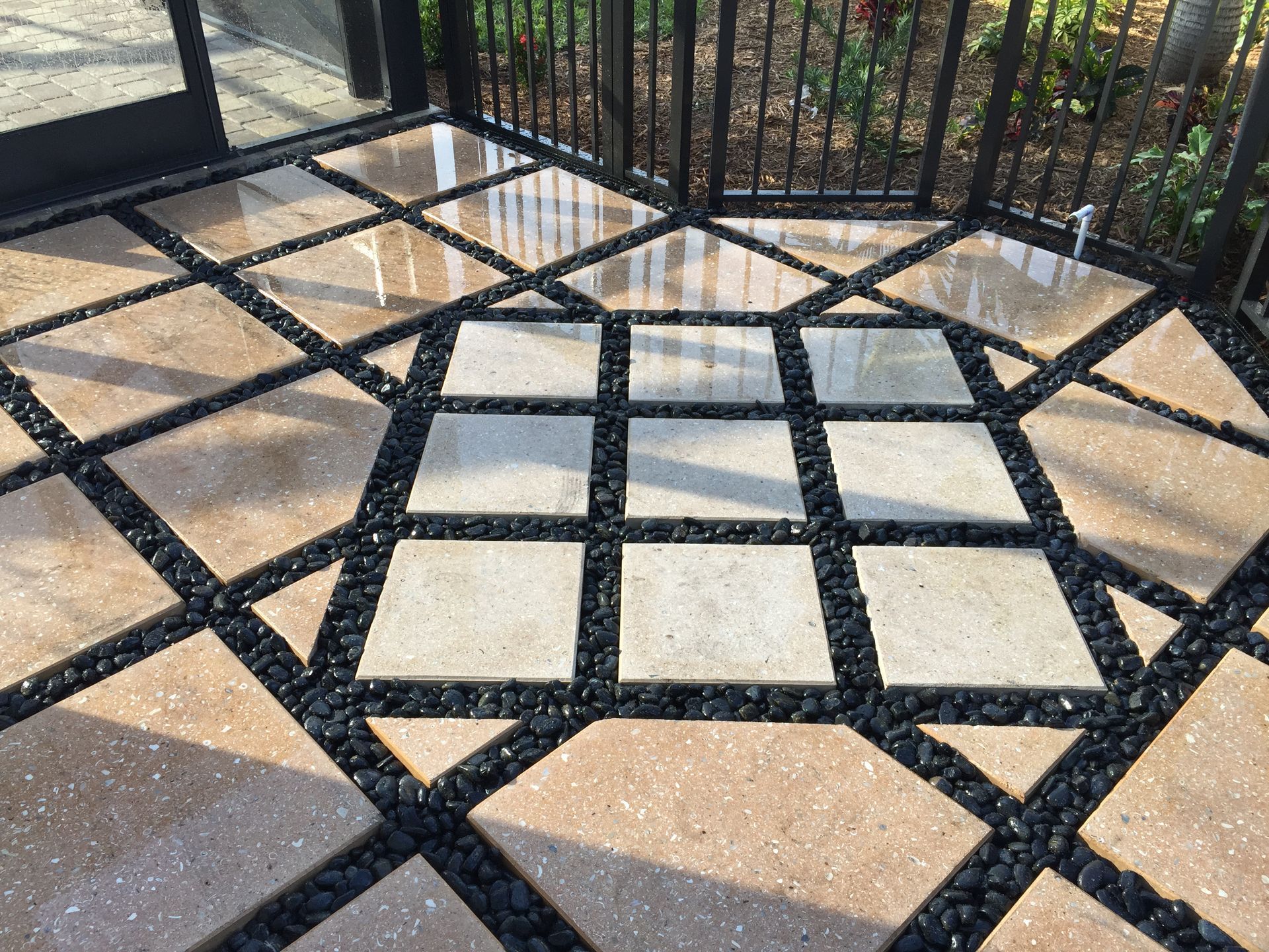 A patio with a geometric pattern of tiles and gravel.