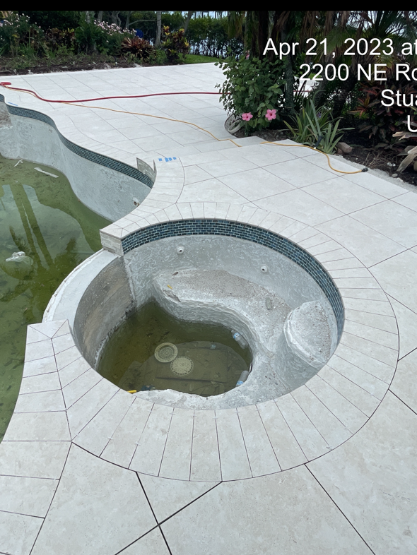 A swimming pool with a hot tub in the middle of it