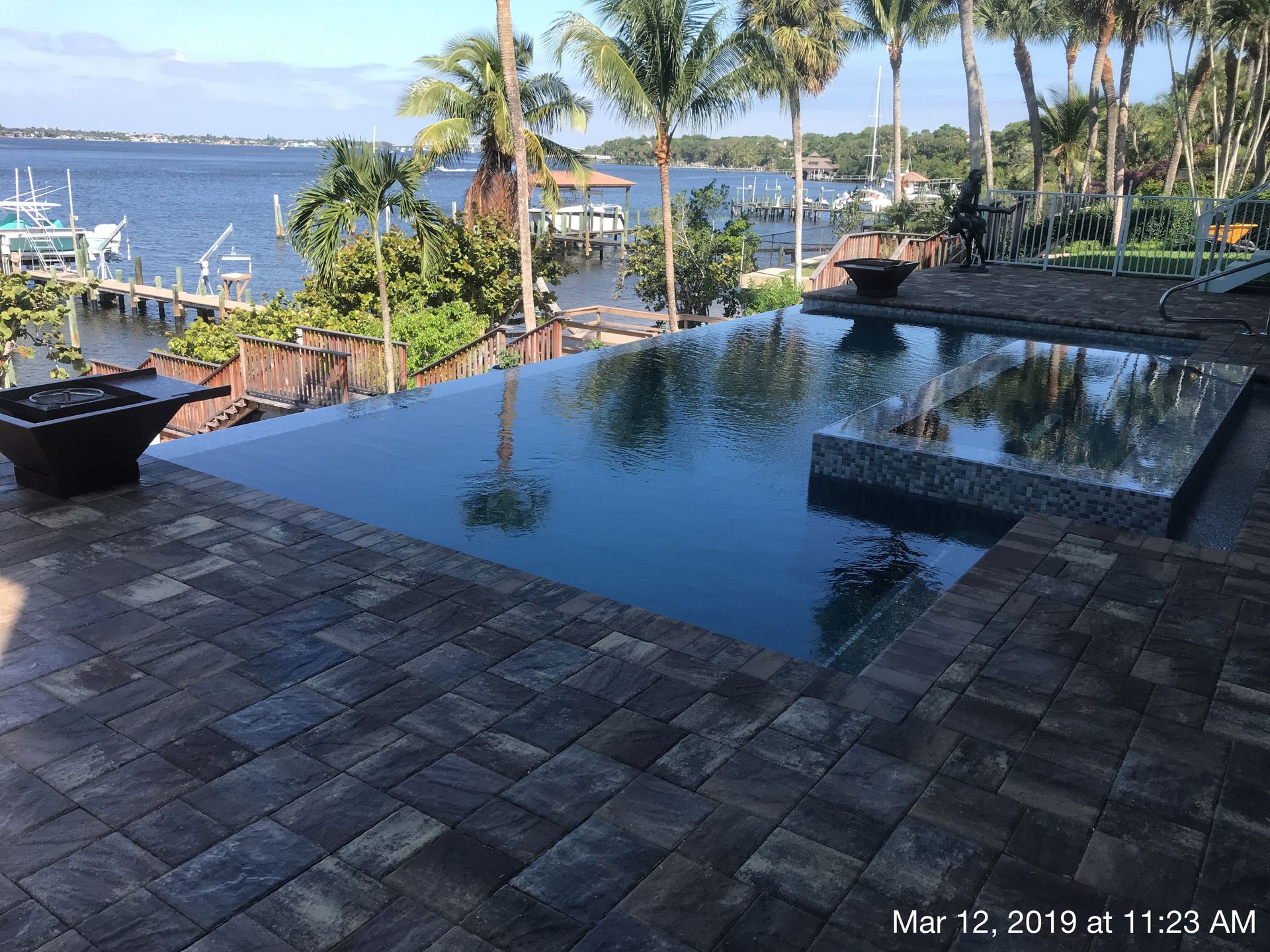A swimming pool with a view of the ocean and palm trees