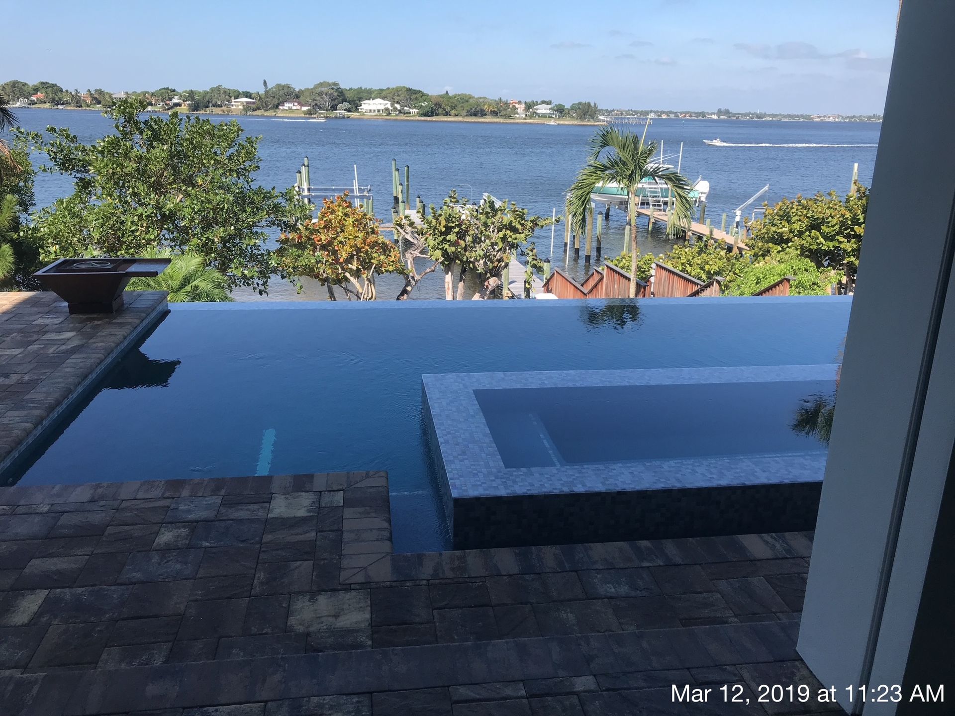 A large swimming pool with a view of a body of water.