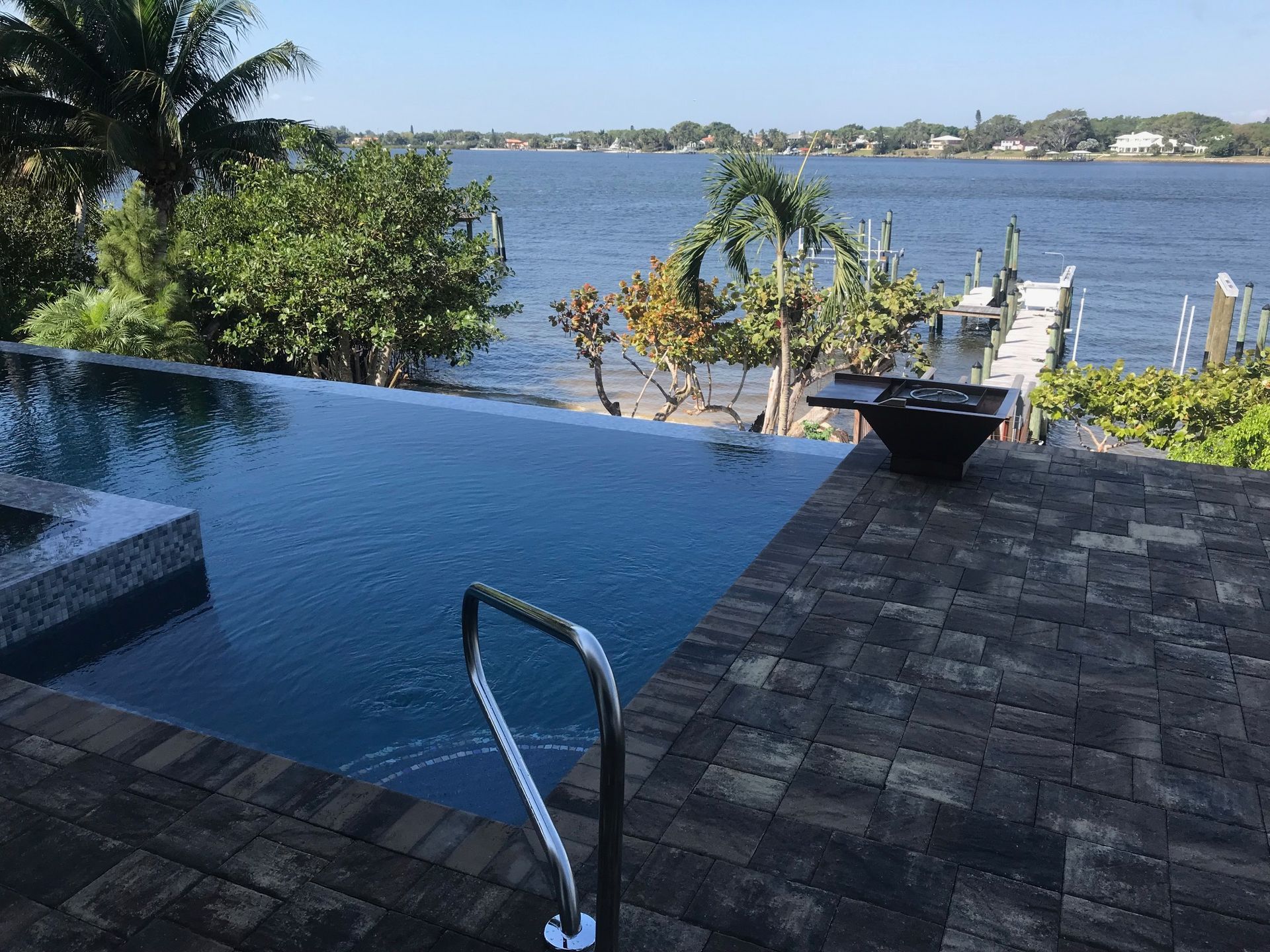 A large swimming pool with a view of a body of water.