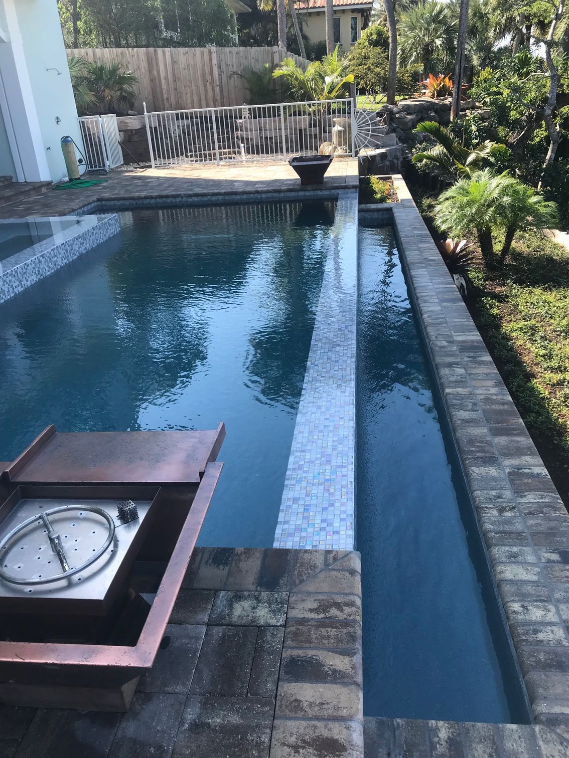 A large swimming pool with a fire pit in the middle of it.