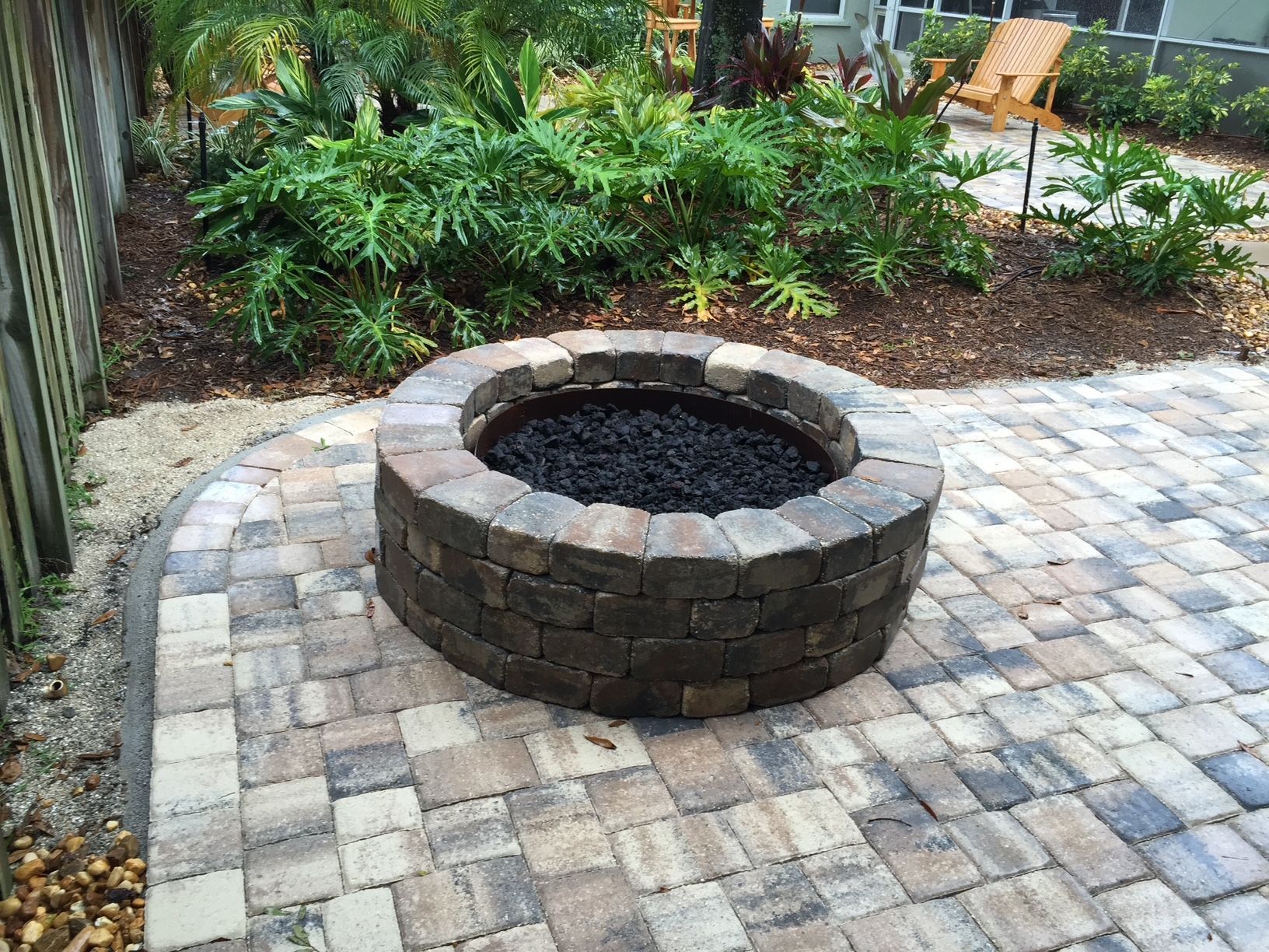 A fire pit is sitting on top of a brick patio.